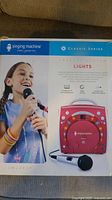 Front of retail box showing karaoke machine and microphone