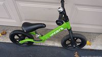 Full left side view of green Unners balance bike