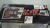 Front of boxed Paper Jamz AC/DC guitar