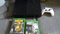 Full view of Xbox One console, white controller, two game cases