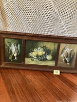 Full view of framed triptych showing three printed panels and wood frame