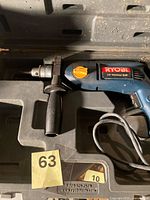 Drill in carry case with side handle and cord visible