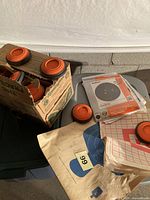 Box of Remington clay pigeons and stacks of various paper targets on table