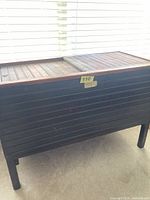 Front view of wooden slatted cooler chest, shows overall form and lid