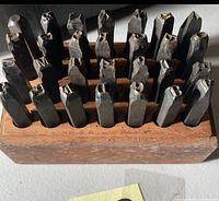Front view of punches seated in wooden block