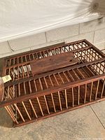Top view of wooden chicken carrier showing spindle bars and hinged lid