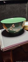 Side view of one green Pier 1 bowl on notebook