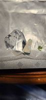 All three stones inside plastic bag: snowflake obsidian, larimar, peridot