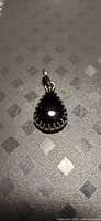 Front view of teardrop black onyx pendant in silver setting