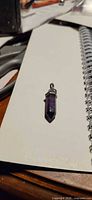 Front view of purple fluorite crystal point pendant with silver-tone cap and bail
