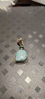Front view of pendant showing larimar, topaz, and bail