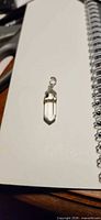 Full view of quartz pendant on notebook background