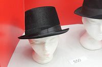 Black felt top hat on mannequin head, grosgrain band visible