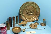 Group shot of all brass items including charger, lamp, snuffer, candlesticks, casings, dish, tray with miniatures