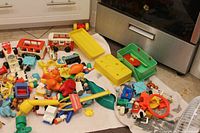 Overall view of assorted Fisher-Price toys spread on towel