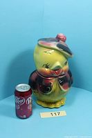 Full view of bird cookie jar beside soda can for scale