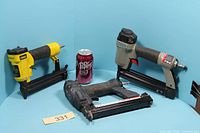 Group shot of three brad nailers with can for scale