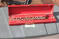 Instrument in open red wooden case showing full button keyboard and interior