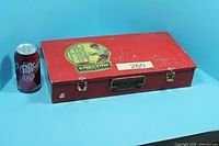 Closed red metal Erector case beside soda can for scale