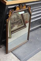 Full view of rectangular wood framed mirror leaning against toolbox
