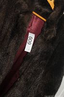 Close-up of fur texture and interior maroon lining with lot tag
