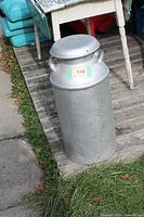 Full view of silver painted metal milk can with lid