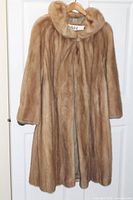 Front view of full-length brown mink coat on hanger