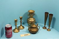 Full lot showing all brass items: 2 candlesticks, 2 flower holders, teapot, embossed vase