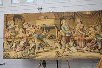 Full view of framed woven tapestry on easel