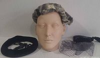 Front view of three vintage headpieces on mannequin