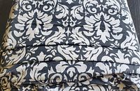 Folded duvet cover showing black and white damask pattern