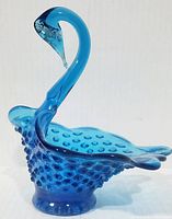 Left profile of turquoise hobnail glass swan dish
