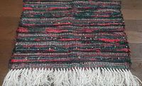 Full view of rectangular multicolour rag rug with fringe