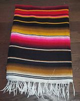 Blanket folded showing stripe colours and fringe