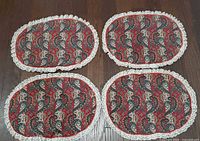 Four oval paisley placemats displayed on floor