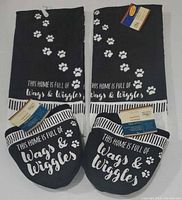 Full set of two oven mitts and two tea towels showing design and tags