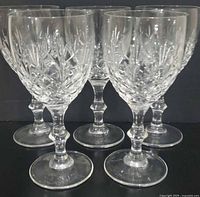 Front view of five matching cut crystal wine goblets