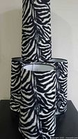 Four zebra print fabric lamp shades stacked showing pattern and shape