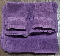 Stack of plum purple towels showing all six pieces