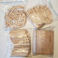 Four bags of assorted wooden craft sticks in various sizes