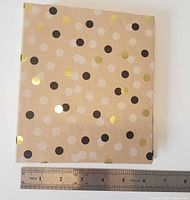 Front of closed booklet beside ruler showing width ~6"