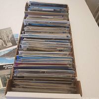 Long cardboard box packed with sleeved postcards