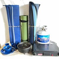 Full lot showing stove, propane cylinder, Dutch oven, enamelware, rolled mats