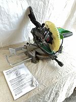 Full view of Hitachi C10FCH2 miter saw with dust bag and manual