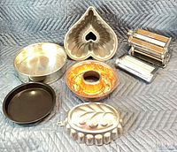 Entire lot showing pasta maker, cutter attachment and five pieces of bakeware