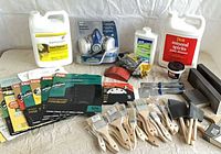 Full layout of jugs, respirator, sandpaper packs, brushes, rollers, sanding blocks, contact paper, spackling