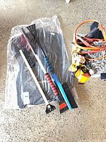 Overall lot showing floor mats in bag, booster cables, snow brushes