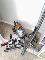 Overall lot with vacuum body, hose, wand, floor head, and small tools