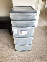 Front view showing four clear drawers and top lid