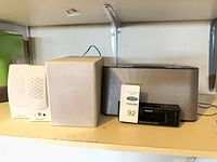 Full lot showing Altec Lansing satellite speaker, subwoofer, silver docking speaker, Sony clock radio